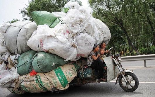 Famille sur une moto transportant des déchets