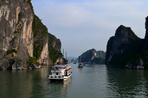 Boat cruising through the mountains of the Halong Bay